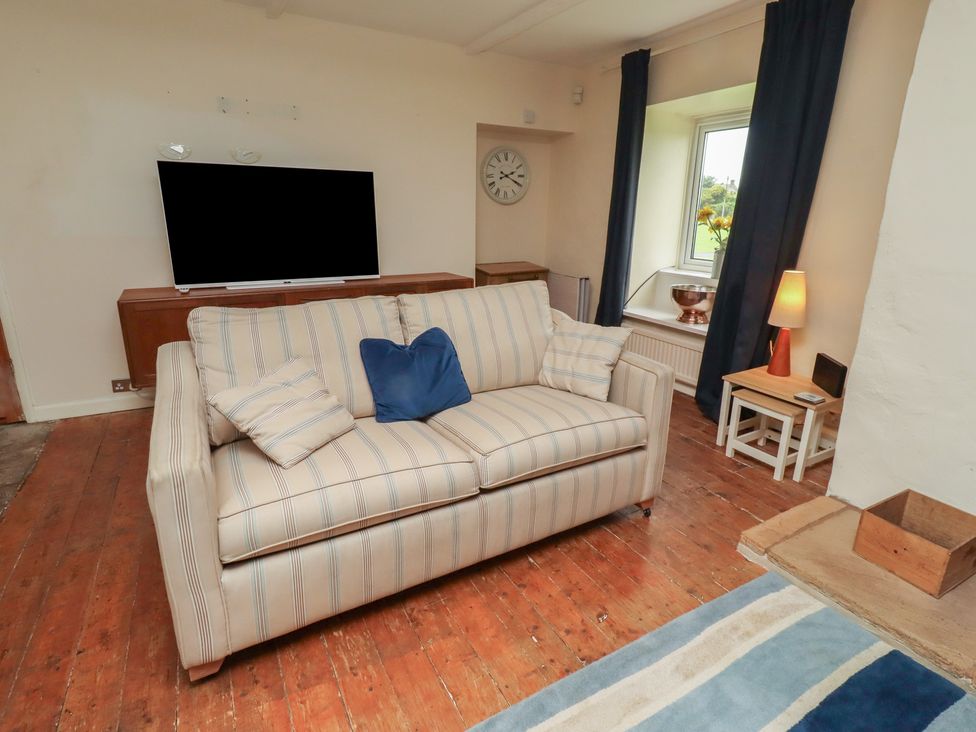 A living room with a sofa and television at ASTA COTTAGE in Cresswell
