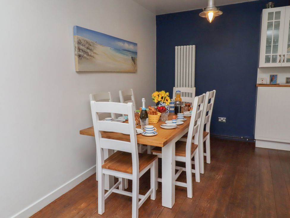 A dining room with a table set for meals at ASTA COTTAGE Cresswell