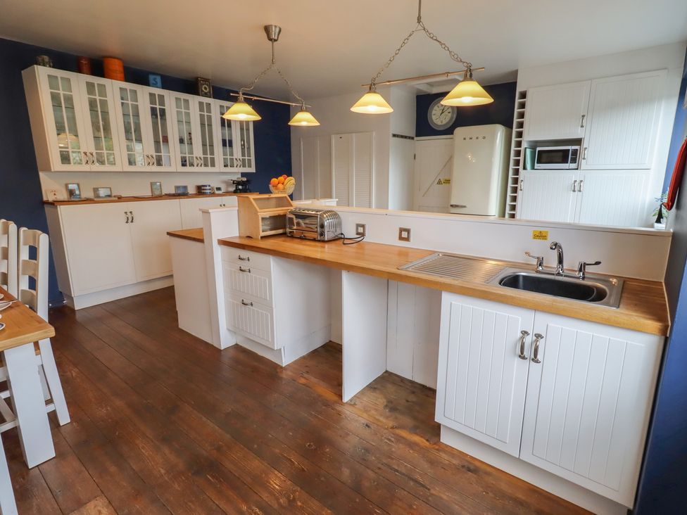 A kitchen with cabinets, sink, and appliances at ASTA COTTAGE in Cresswell
