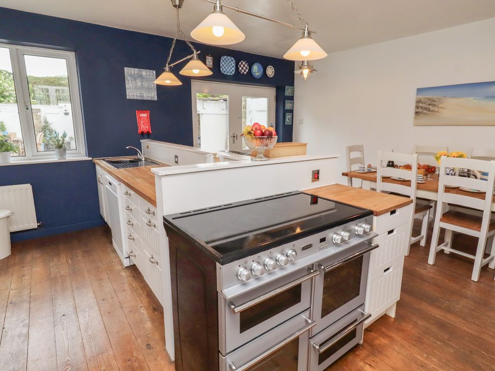 A kitchen with stove and seating area at ASTA COTTAGE in Cresswell