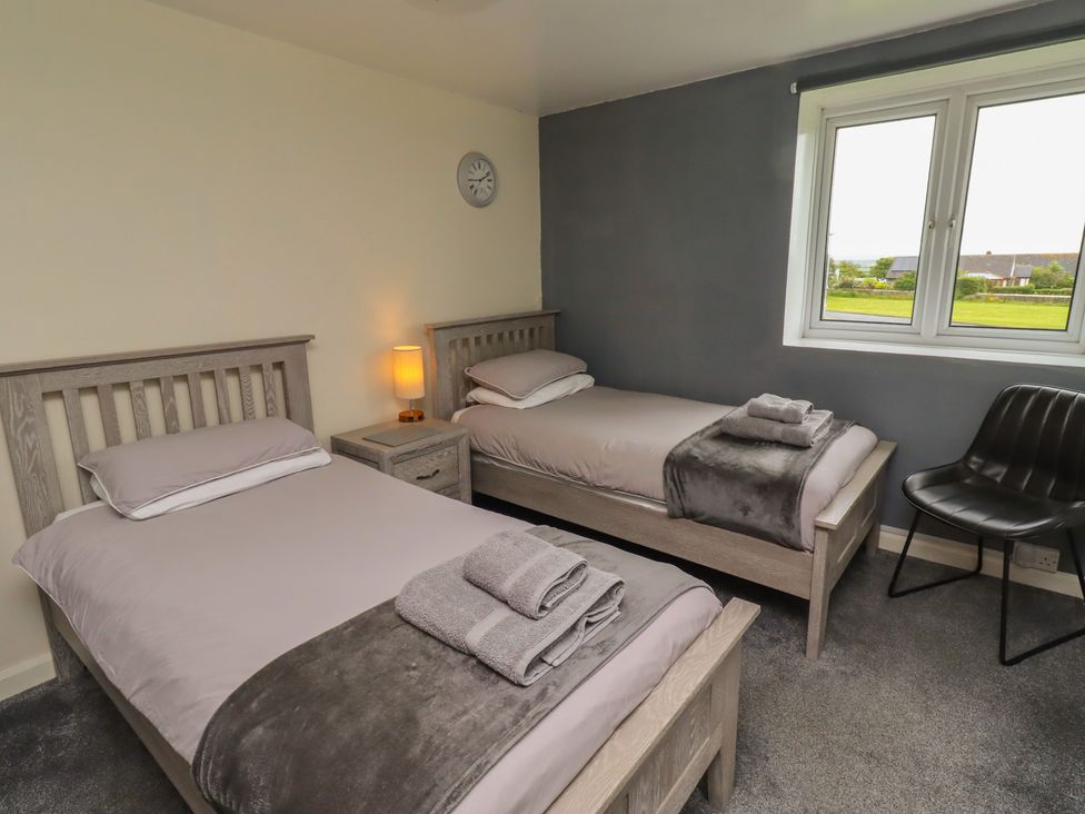 A bedroom with two single beds and a window at ASTA COTTAGE Cresswell