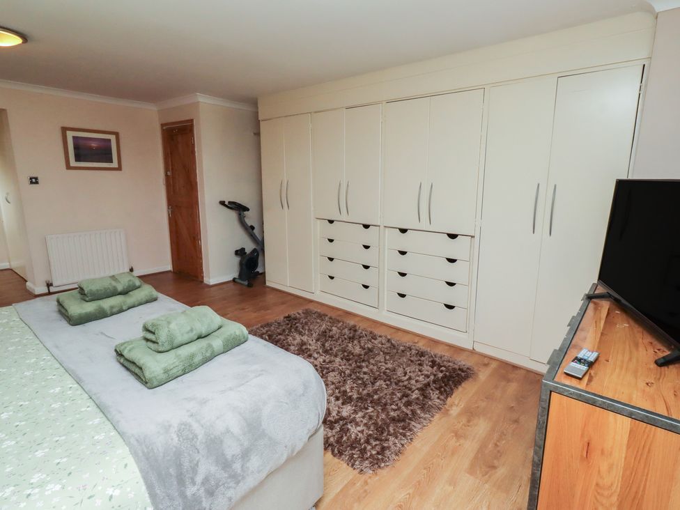 A bedroom with a bed, closet, and television at ASTA COTTAGE in Cresswell