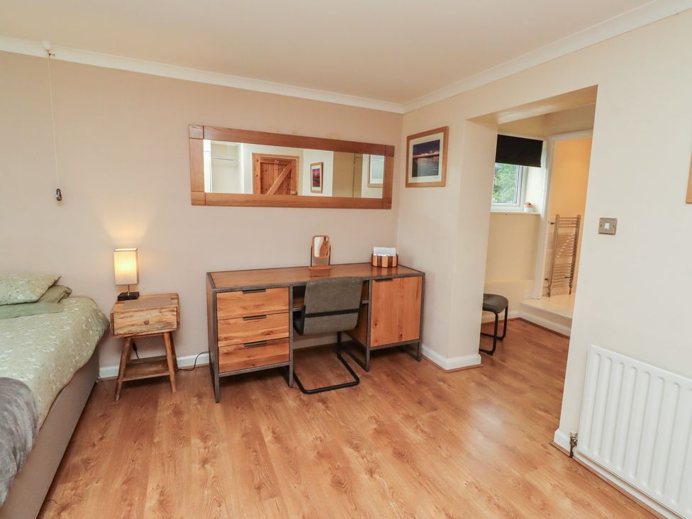 A bedroom with a bed, desk, and mirror at ASTA COTTAGE in Cresswell