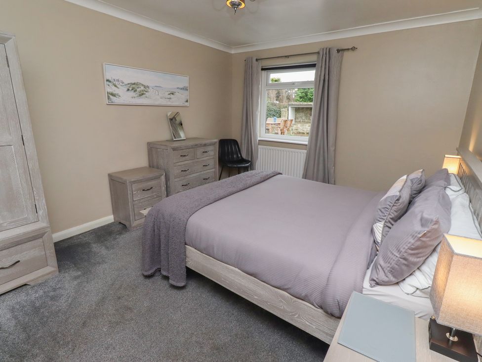 A bedroom with a bed, nightstand, and dresser at ASTA COTTAGE in Cresswell