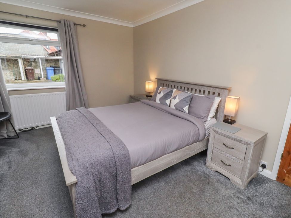A bedroom with a bed and bedside tables at ASTA COTTAGE in Cresswell