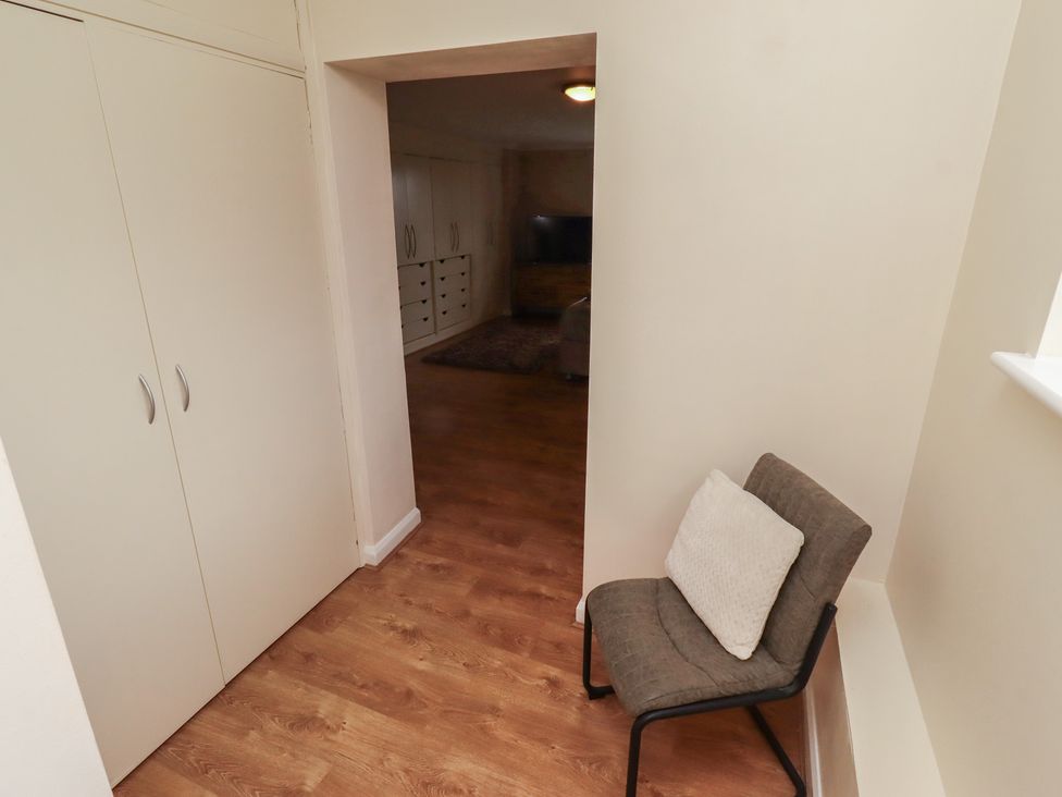 A hallway with a chair and closet at ASTA COTTAGE in Cresswell