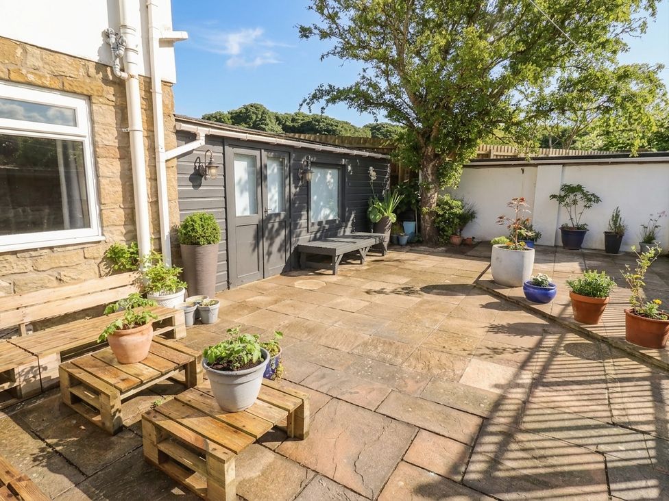 A garden area with patio and planters at ASTA COTTAGE in Cresswell