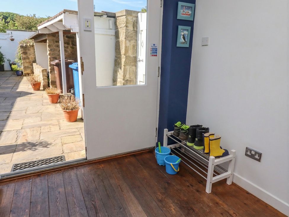 An entryway with boots on a rack at ASTA COTTAGE in Cresswell