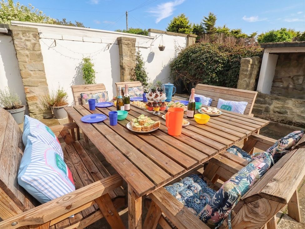 A garden dining setup with food and drinks at ASTA COTTAGE Cresswell