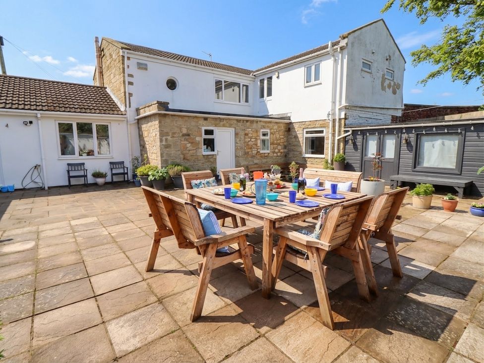 An outdoor dining area with wooden table and chairs at ASTA COTTAGE Cresswell