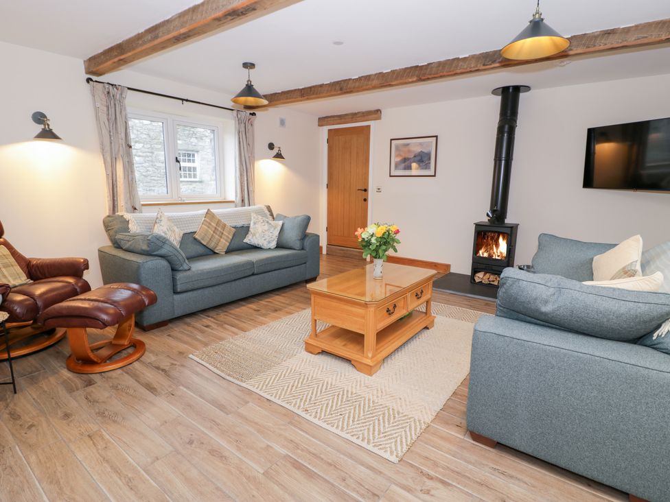A living room with sofas and a fireplace at Merddwr in Cerrigydrudion