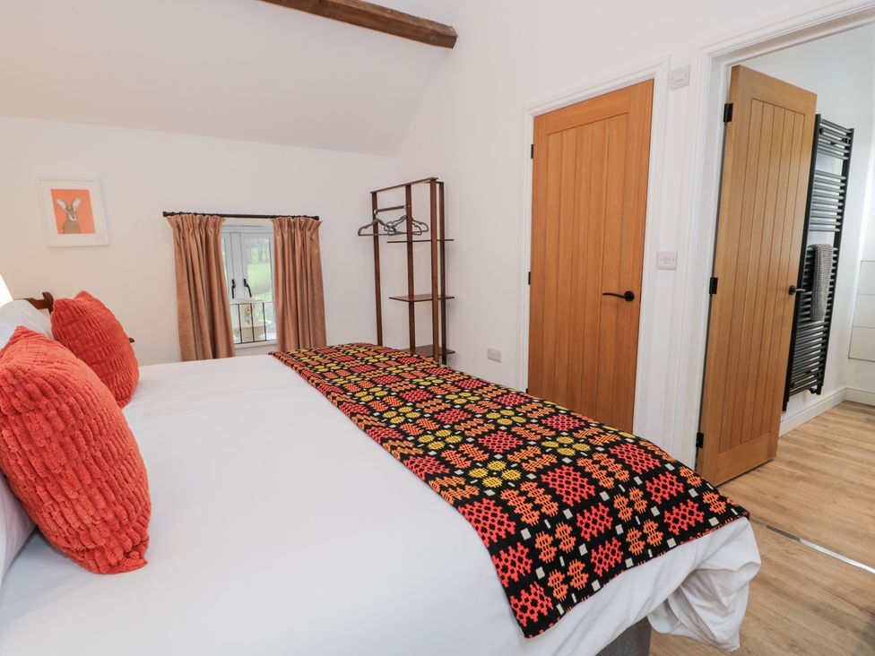 A bedroom with a bed and window at Merddwr in Cerrigydrudion