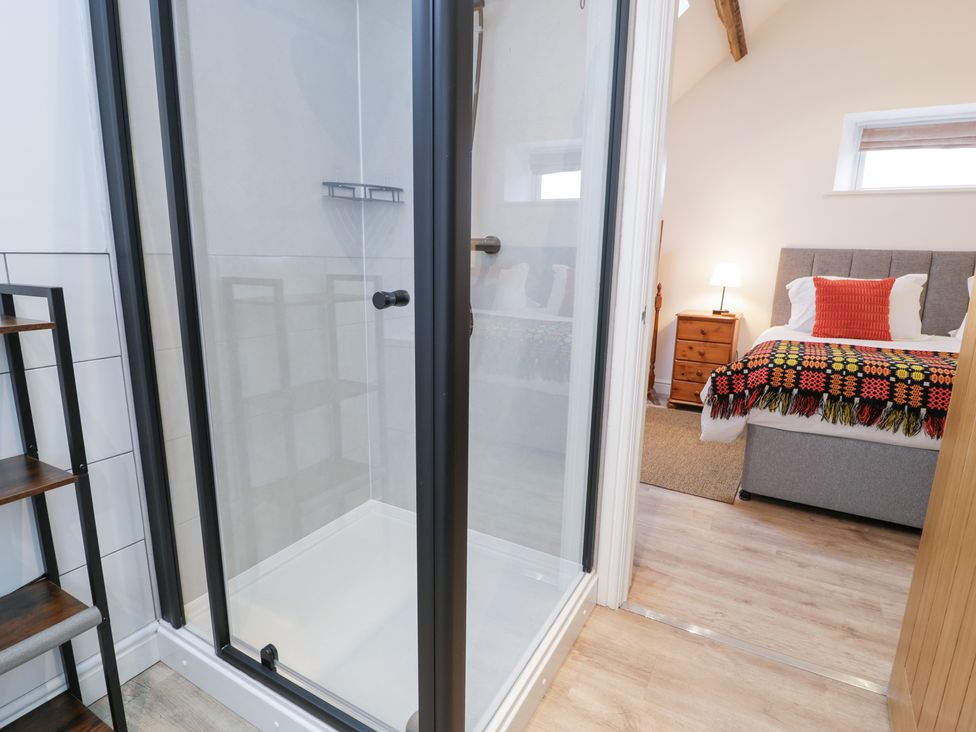 A bathroom with a shower and adjoining bedroom at Merddwr in Cerrigydrudion