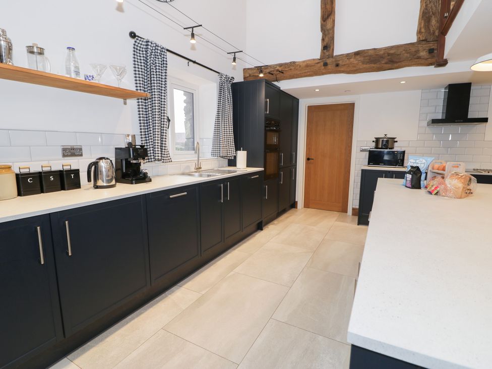 A kitchen with shelves and appliances at Merddwr in Cerrigydrudion