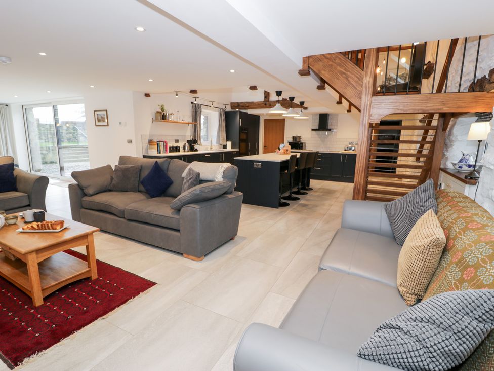 A living room with sofas and a kitchen in Merddwr Cerrigydrudion