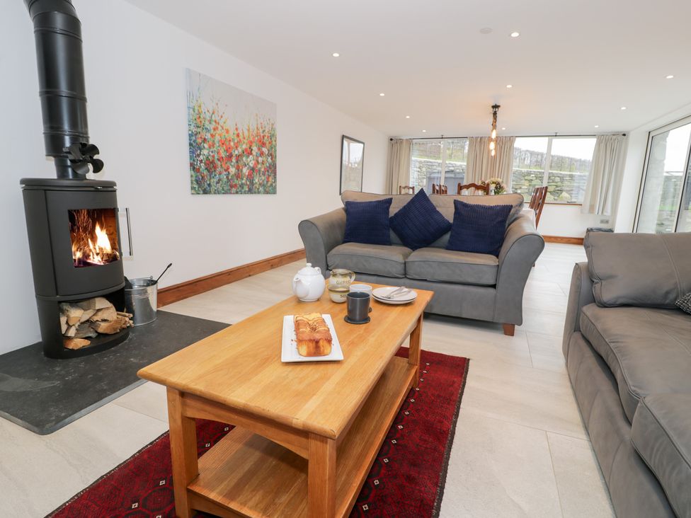 A living room with a fireplace and a coffee table at Merddwr in Cerrigydrudion