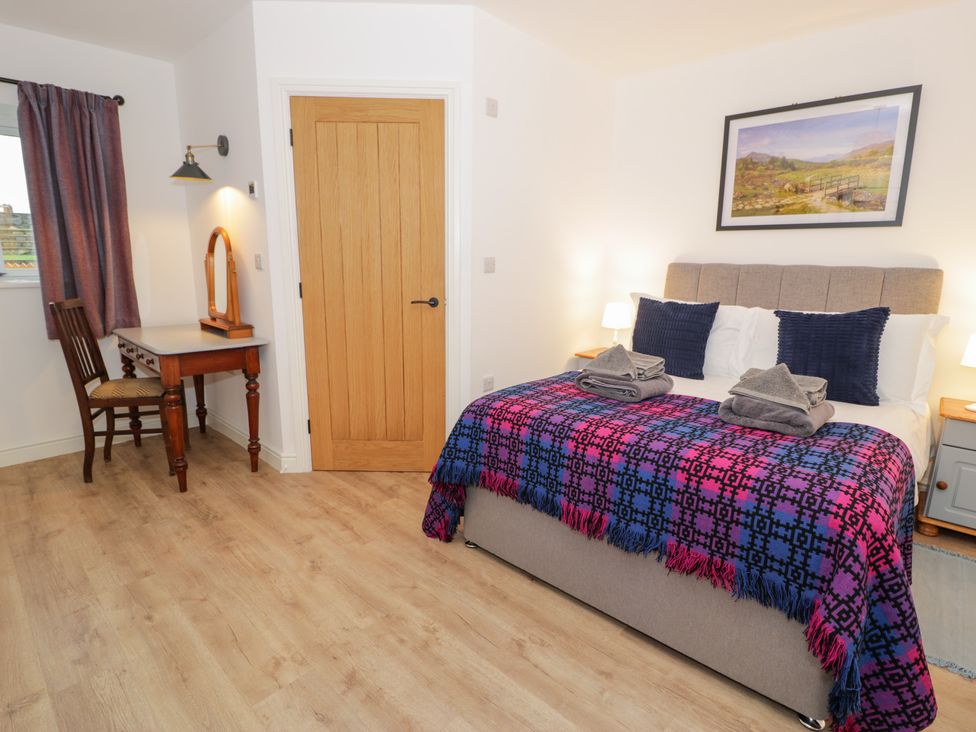 A bedroom with a bed and desk at Merddwr in Cerrigydrudion