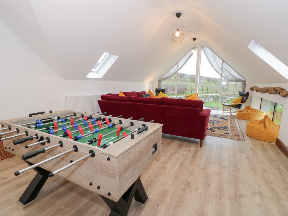 A living room with a foosball table and sofa at Merddwr in Cerrigydrudion