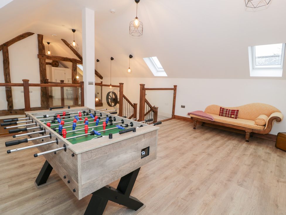 A games room with a foosball table and sofa at Merddwr in Cerrigydrudion