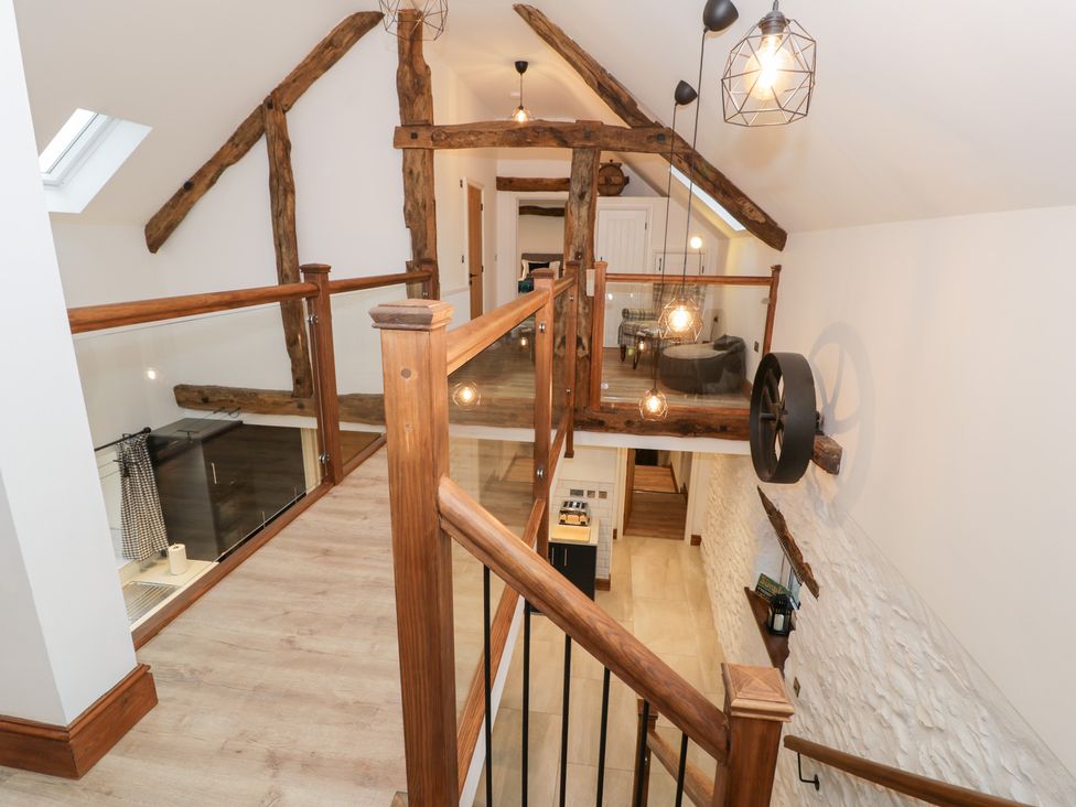 A landing with wooden staircase and light fixtures at Merddwr in Cerrigydrudion
