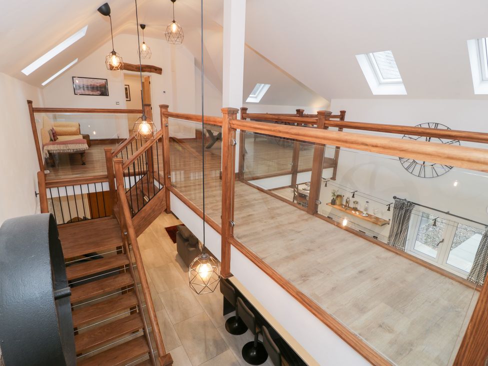 A staircase with railing and hanging lights at Merddwr in Cerrigydrudion