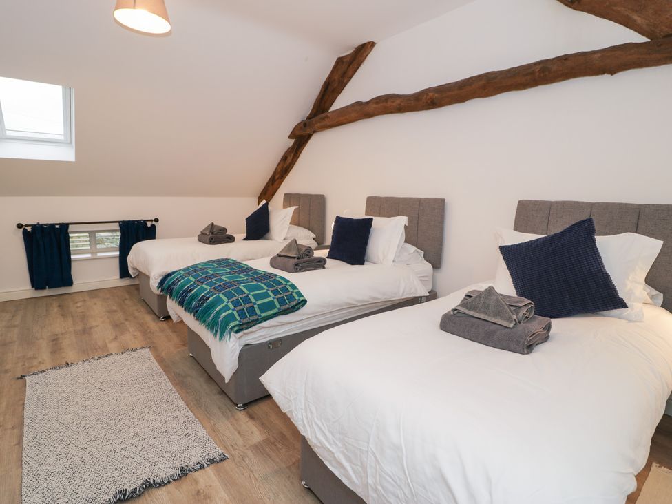 A bedroom with three beds at Merddwr in Cerrigydrudion