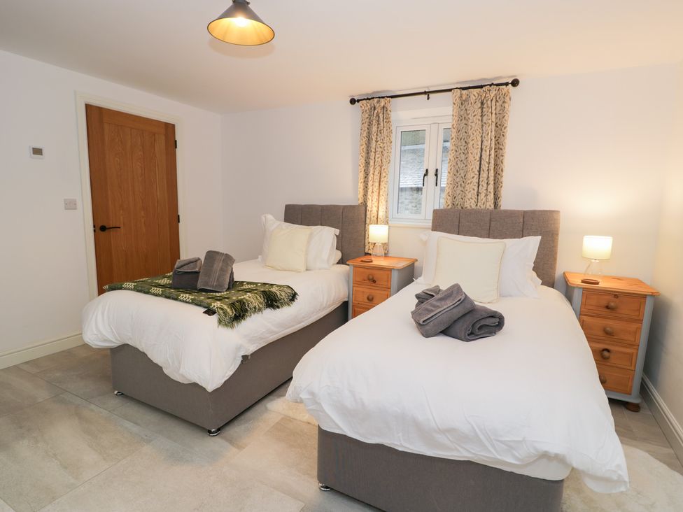 A bedroom with two single beds and bedside tables at Merddwr in Cerrigydrudion