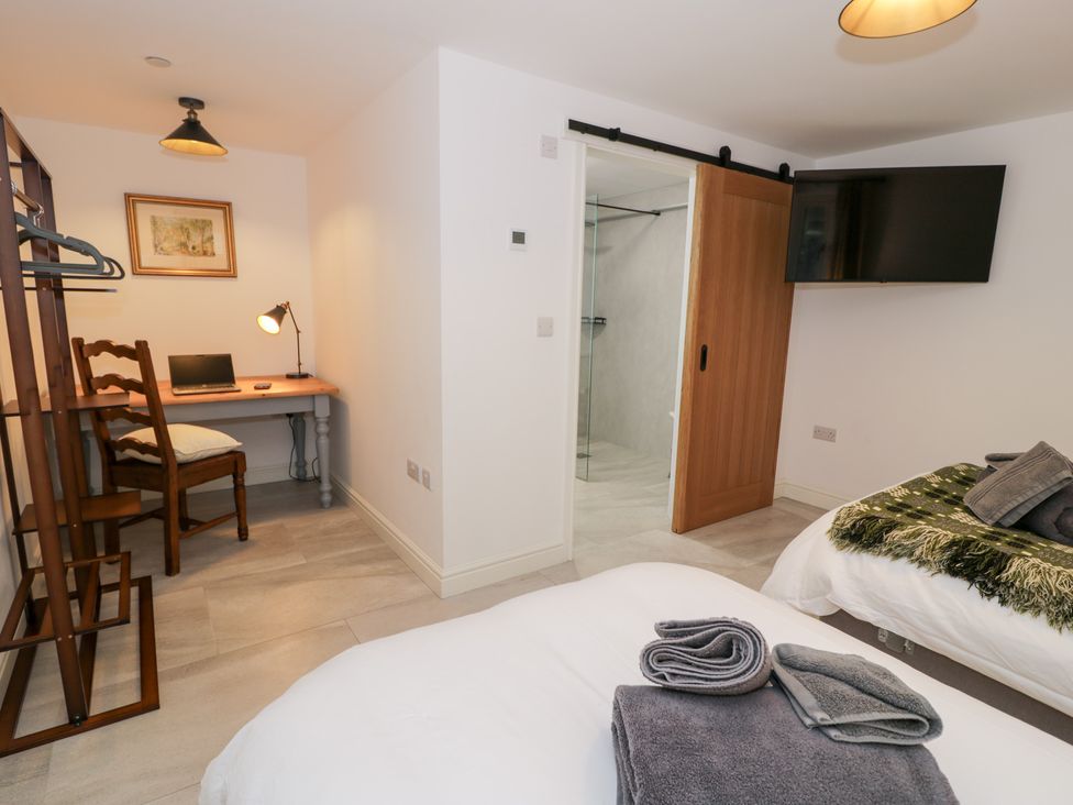 A bedroom with a bed, desk and chair at Merddwr in Cerrigydrudion