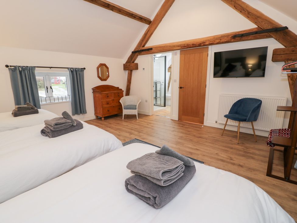 A bedroom with two beds and a dresser at Merddwr in Cerrigydrudion