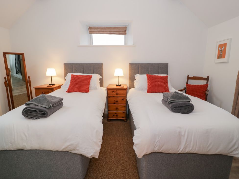 A bedroom with two single beds and nightstands at Merddwr in Cerrigydrudion