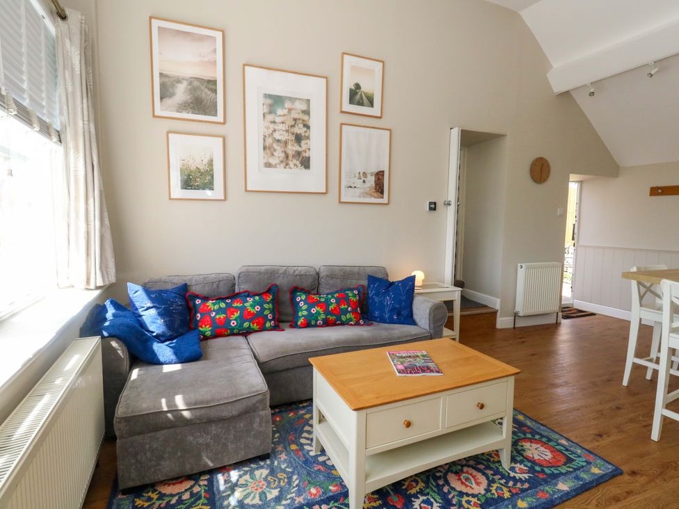 A living room with a sofa and coffee table at Sea Pink Cottage in Langton Matravers