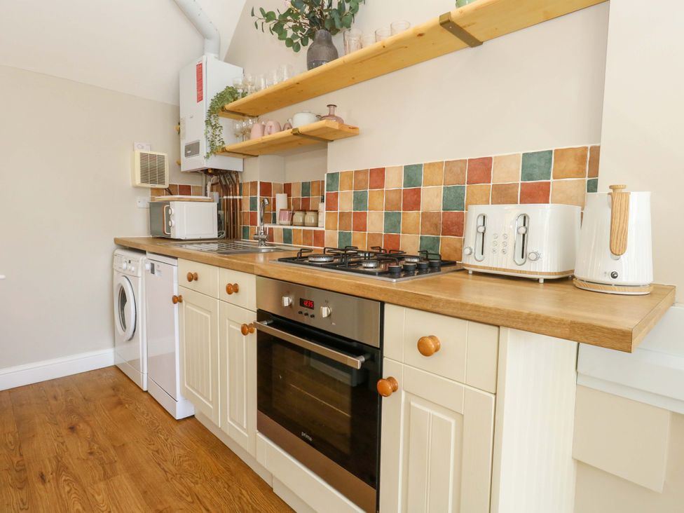 A kitchen with various appliances and cookware at Sea Pink Cottage in Langton Matravers