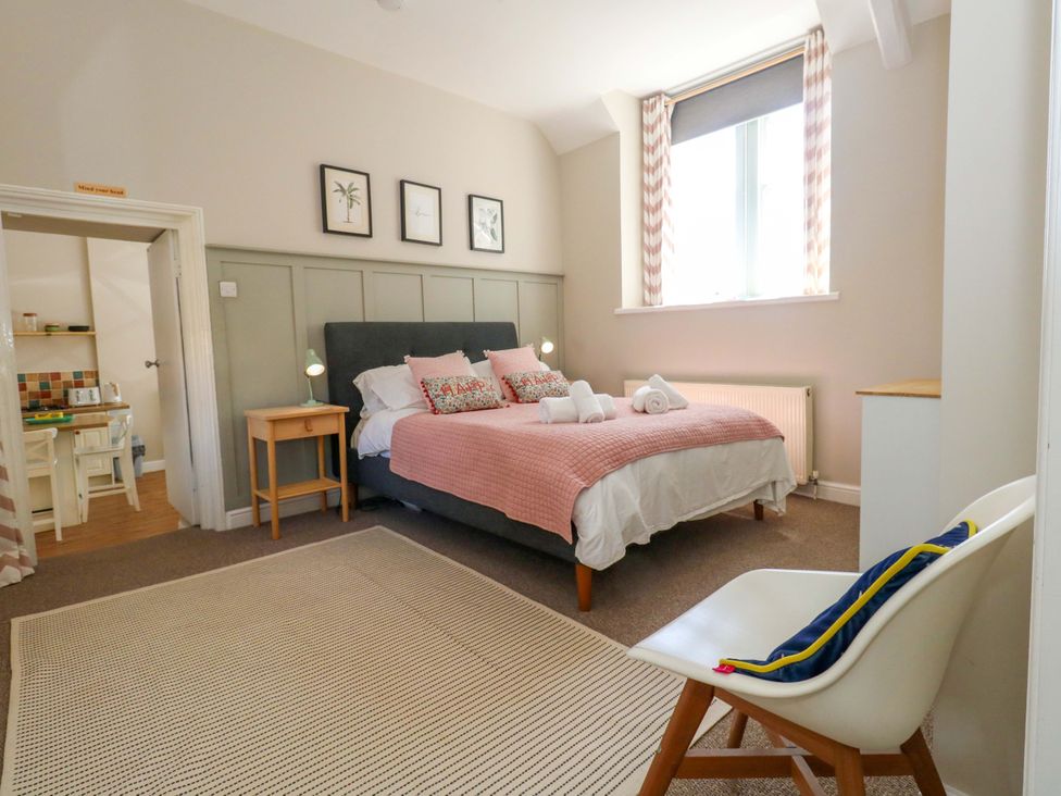 A bedroom with a bed and table at Sea Pink Cottage in Langton Matravers
