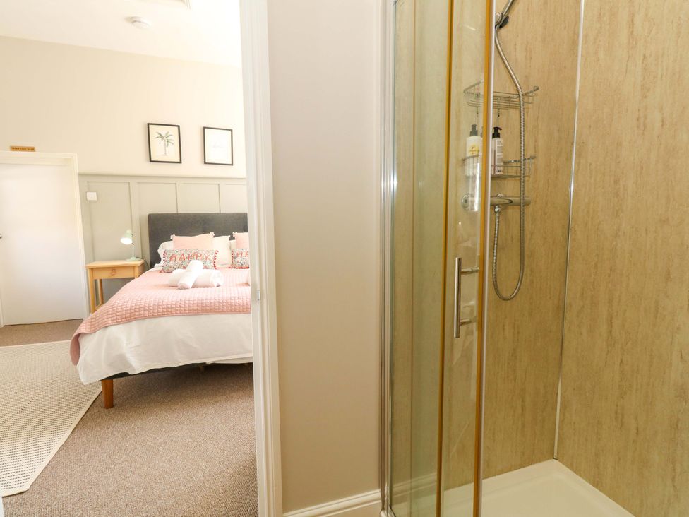 A bedroom with a bed and shower at Sea Pink Cottage in Langton Matravers