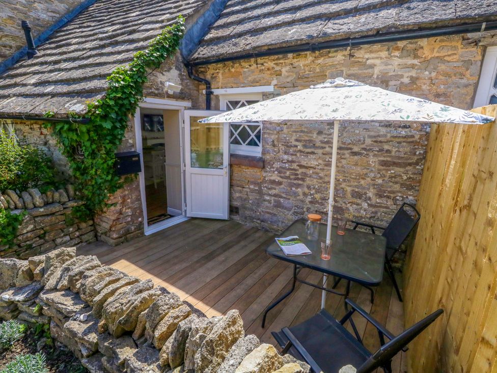 A table and chairs under an umbrella at Sea Pink Cottage in Langton Matravers