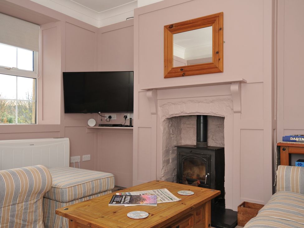 A living room with a television, fireplace, and sofa at Tor View @ Fourwinds, Meldon near Okehampton
