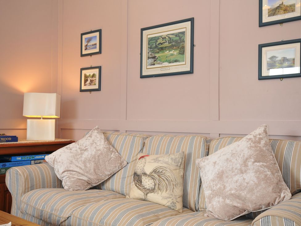 A sofa with cushions and pictures on the wall at Tor View @ Fourwinds Meldon near Okehampton