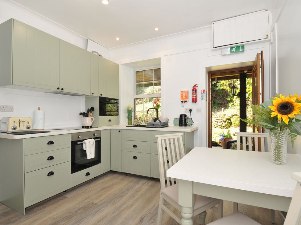 A kitchen with a table and chairs at Tor View @ Fourwinds in Meldon near Okehampton