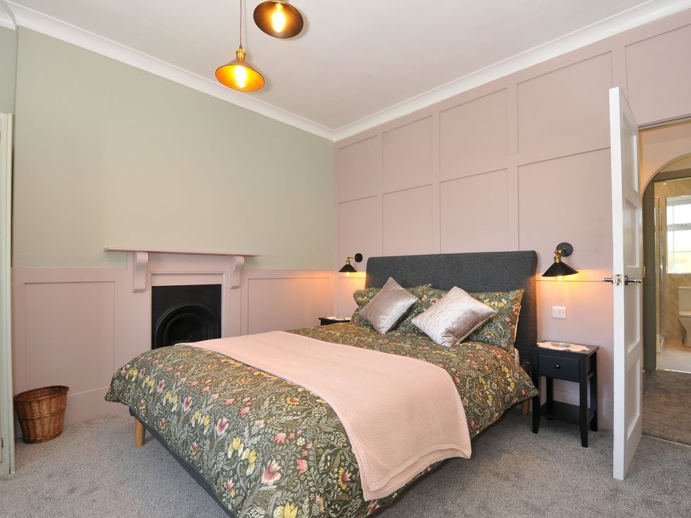 A bedroom with a bed and bedside tables at Tor View @ Fourwinds in Meldon near Okehampton