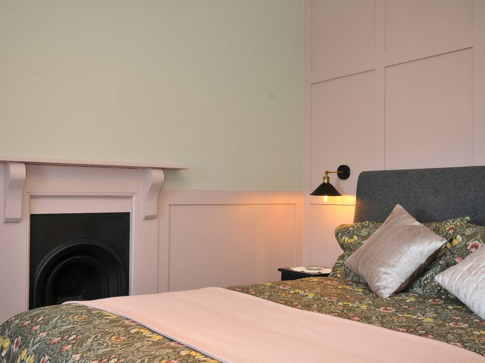A bedroom with a bed and a fireplace at Tor View @ Fourwinds in Meldon near Okehampton