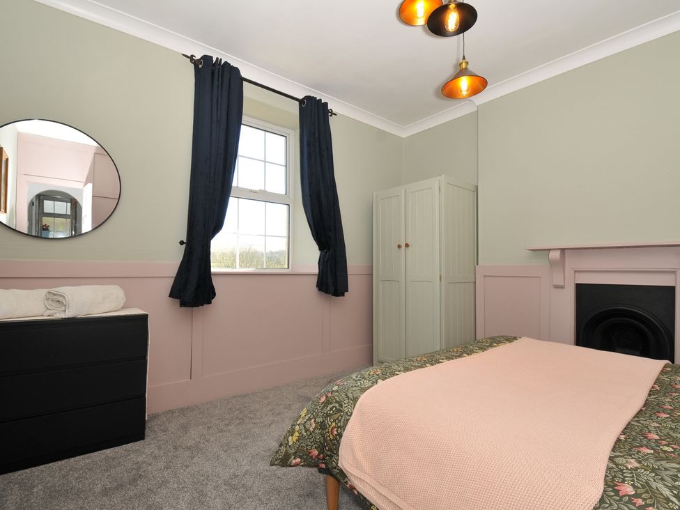 A bedroom with a bed and a wardrobe at Tor View @ Fourwinds, Meldon near Okehampton
