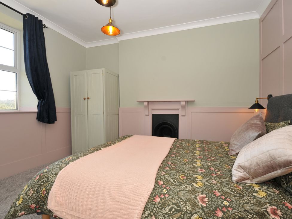 A bedroom with a bed and wardrobe at Tor View @ Fourwinds in Meldon near Okehampton