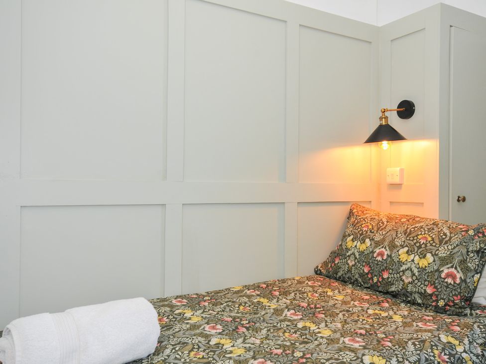 A bedroom with a single bed and bedside lamp at Tor View @ Fourwinds in Meldon near Okehampton