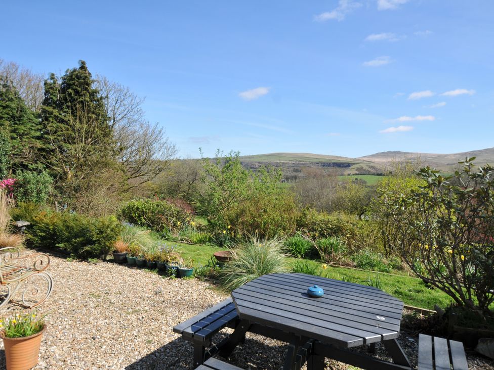A garden with a table and chairs at Tor View @ Fourwinds in Meldon near Okehampton