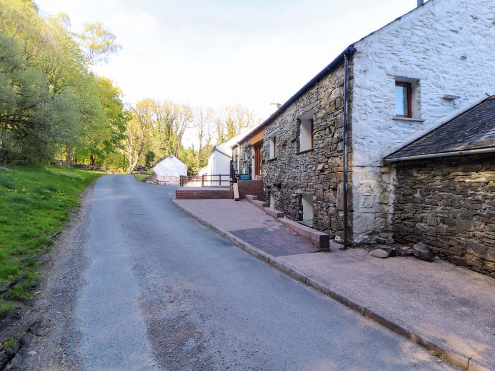 A view of a road beside a stone building at Swallow's Nest Thornthwaite near Braithwaite