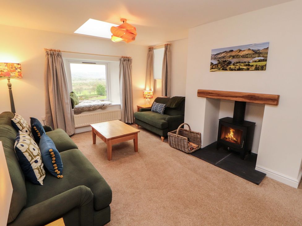 A living room with a sofa and table at Swallow's Nest Thornthwaite near Braithwaite