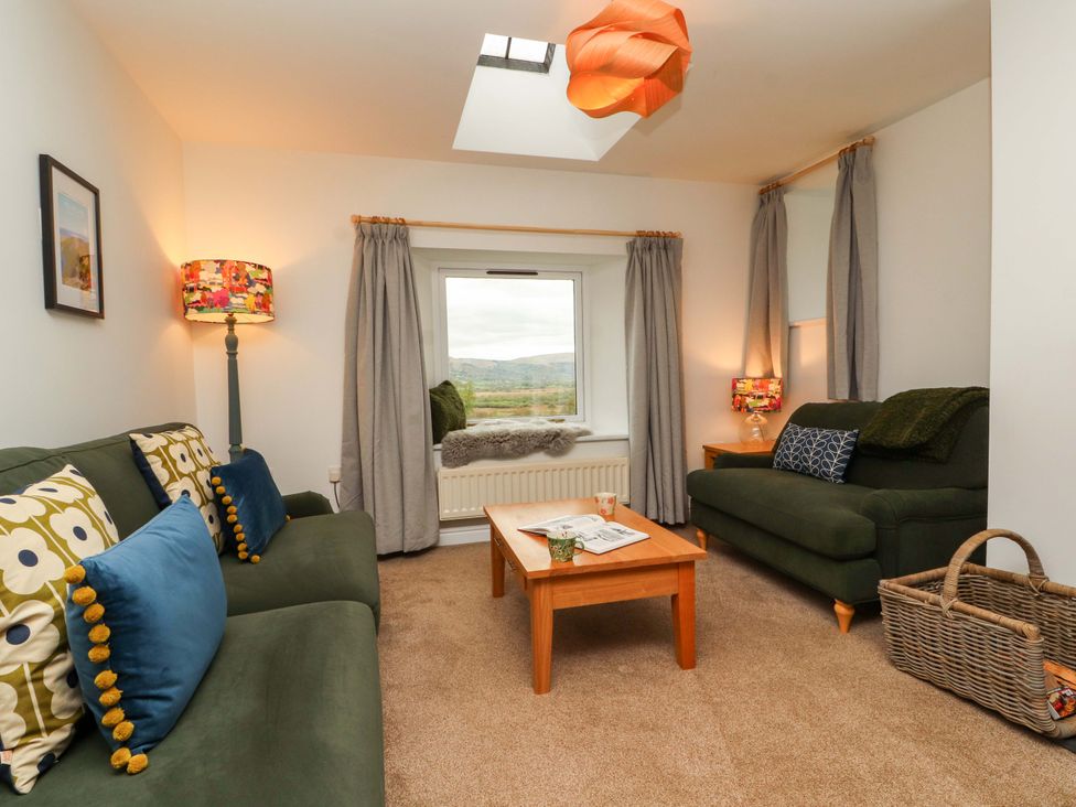 A living room with sofas and a table at Swallow's Nest Thornthwaite near Braithwaite
