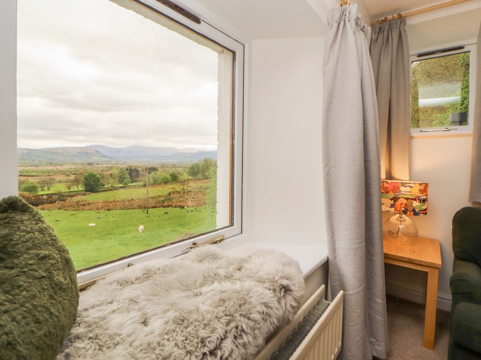 A snug with a window view and a lamp at Swallow's Nest Thornthwaite near Braithwaite