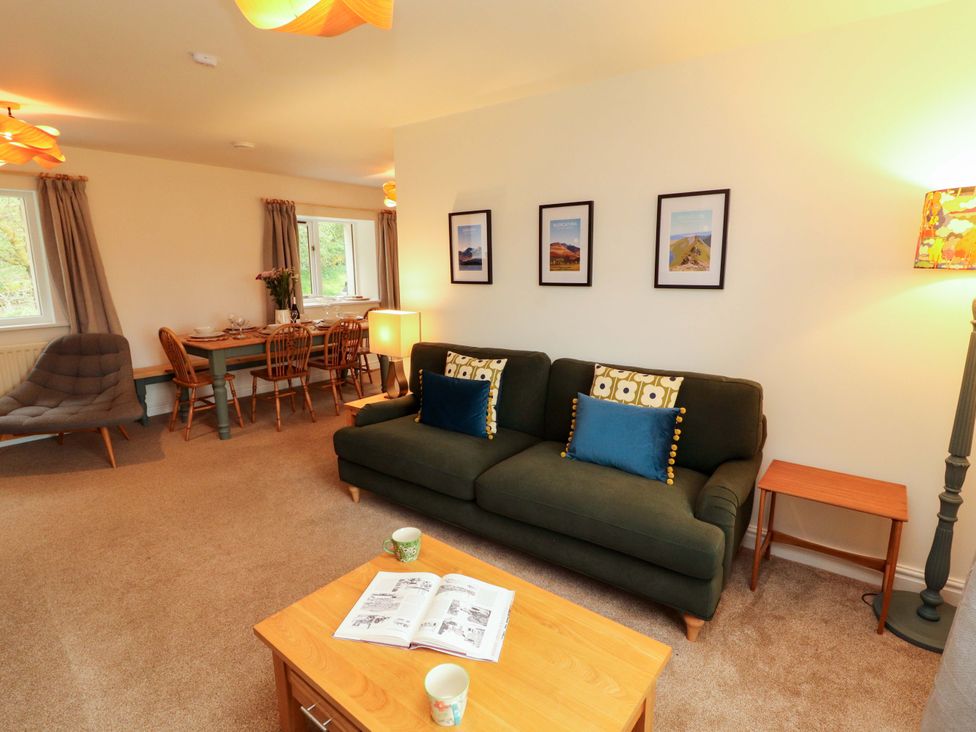 A living room with sofa and dining area at Swallow's Nest Thornthwaite near Braithwaite