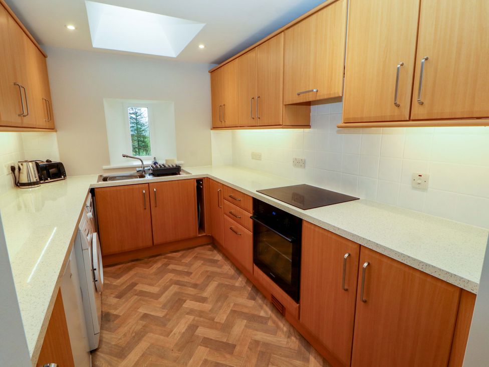 A kitchen with wooden cabinets and a skylight at Swallow's Nest Thornthwaite near Braithwaite